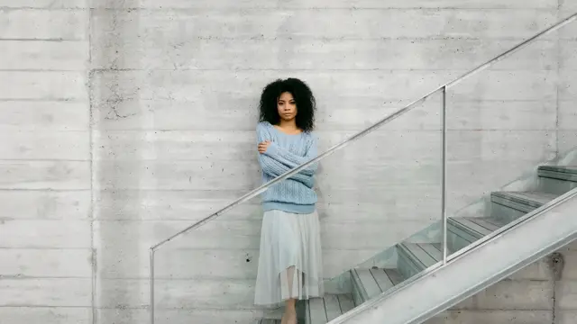 Beautiful young woman standing on stairs outdoors