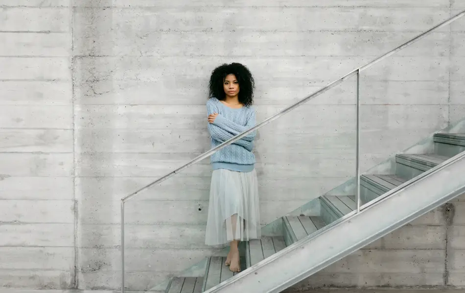 Beautiful young woman standing on stairs outdoors
