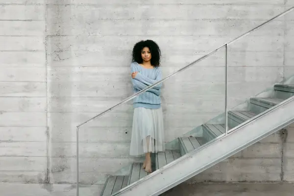 Beautiful young woman standing on stairs outdoors