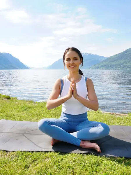 anny johansen viser yogaøvelser foran vakker fjord
