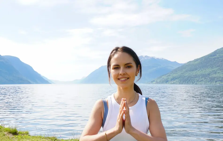 anny johansen viser yogaøvelser foran vakker fjord