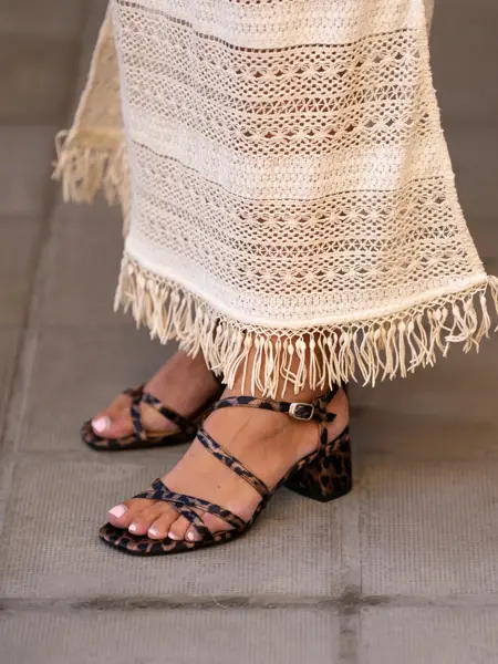 Ben med brunmønstret sandaler og hvit kjole