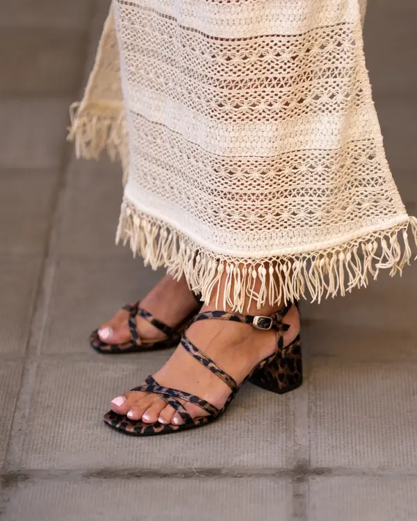 Ben med brunmønstret sandaler og hvit kjole