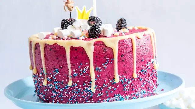 Rosa kake med skogsbærkrem, marsmellows og bær på toppen