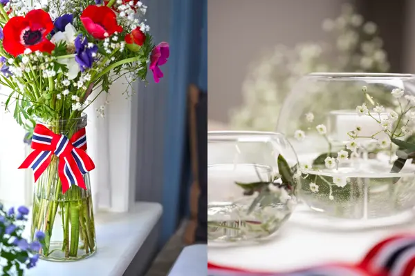 Vase med 17. mai-bånd rundt og stor bukett med fargerike blomster. To små boller fylt med vann og brudeslør og grønne grener.