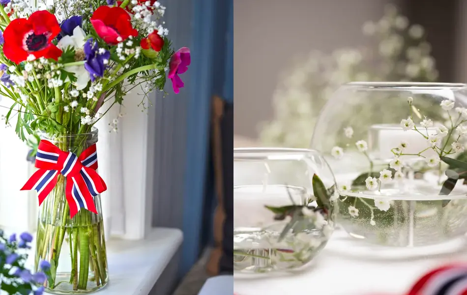 Vase med 17. mai-bånd rundt og stor bukett med fargerike blomster. To små boller fylt med vann og brudeslør og grønne grener.