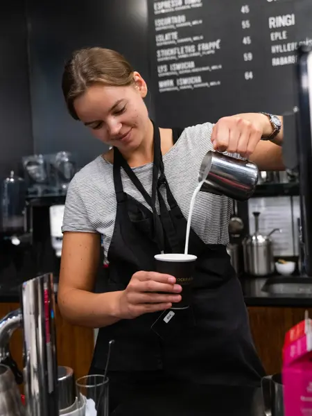 Jente som helder kaffe i en kopp