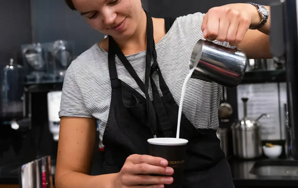 Jente som helder kaffe i en kopp