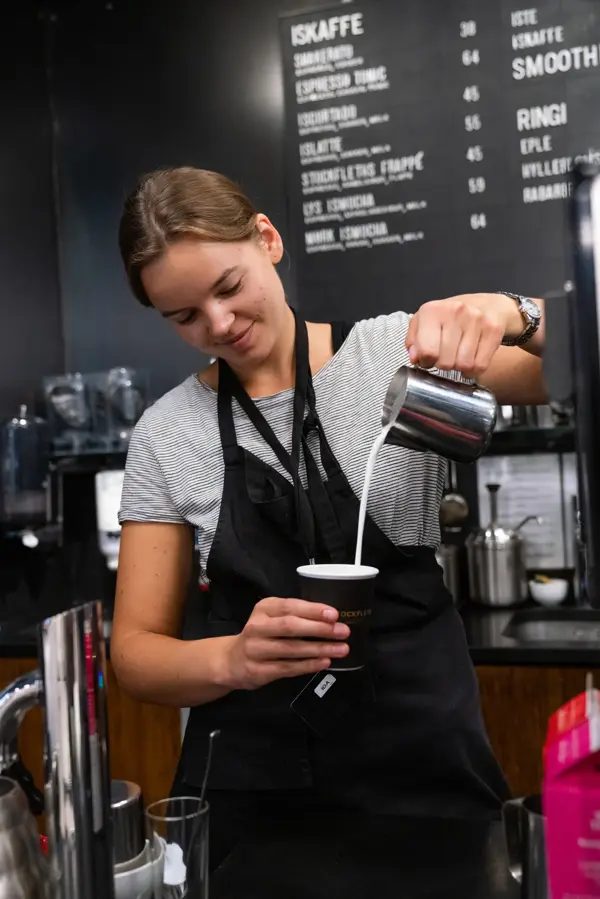 Jente som helder kaffe i en kopp