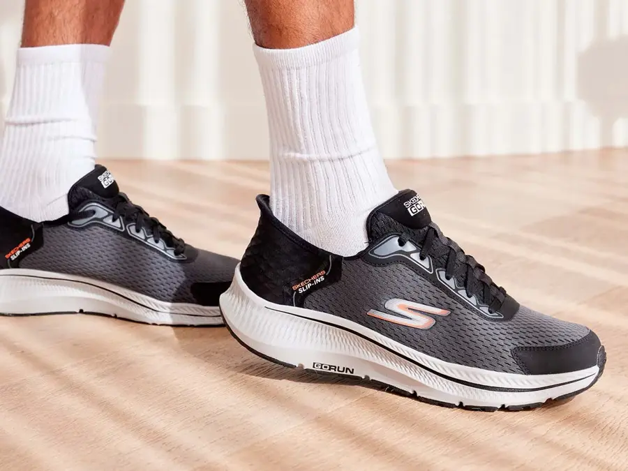 Sorte sko fra skobutikken Skechers på føttene til en mann