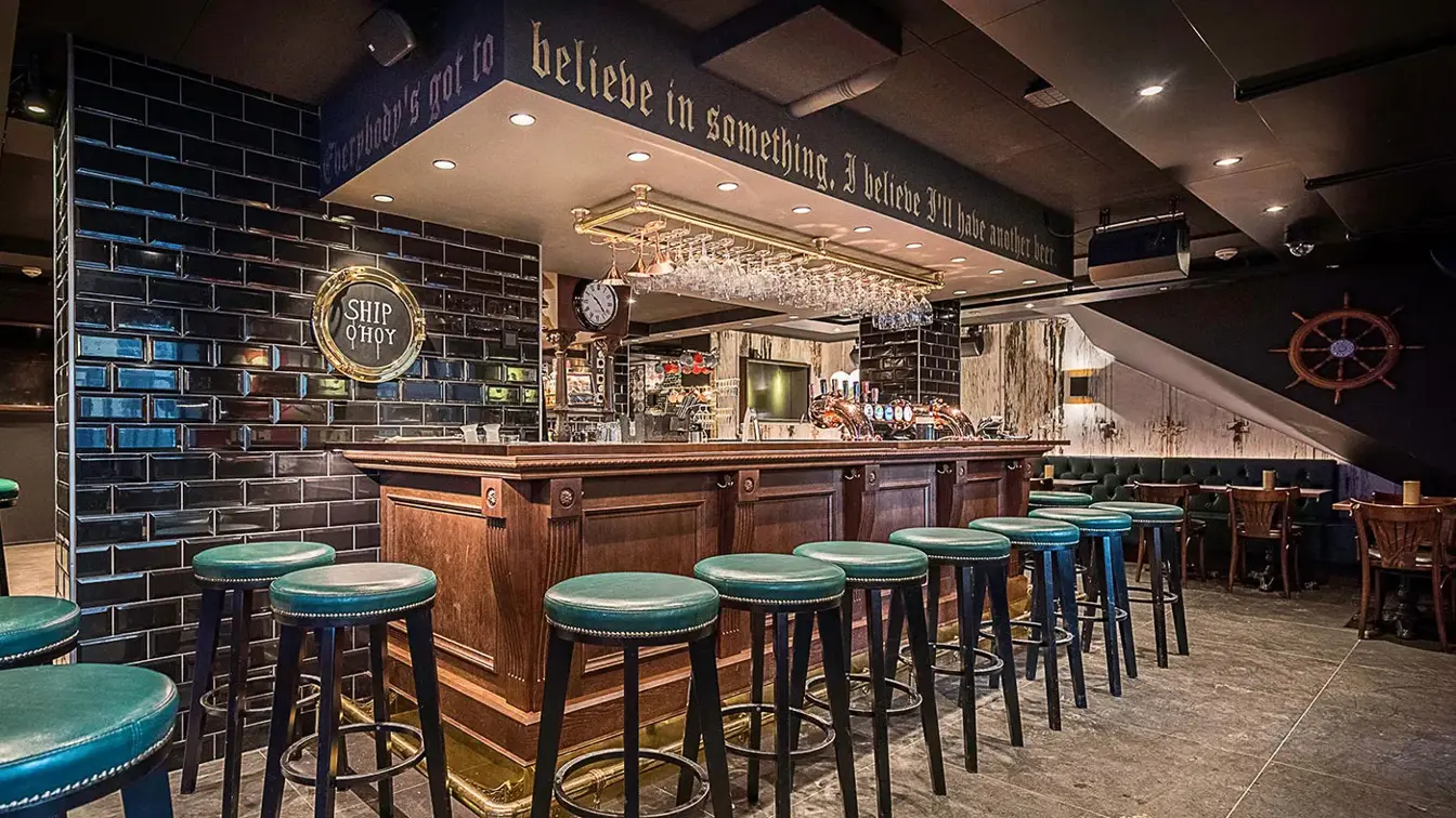 Bardisk med flere barstoler rundt disken.