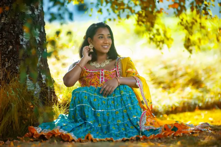 Jente smiler i fargerik drakt