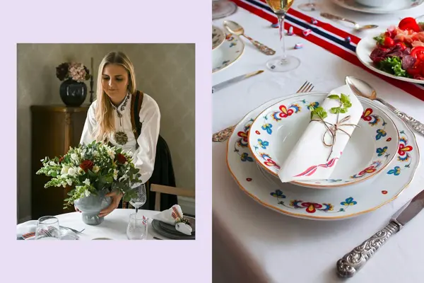 Ung dame i bundad setter en vase med blomster på bordet. Nærbilde at kuvert, bondemønstret servise og sølvbestikk.