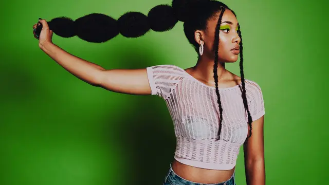 afro amerikansk dame som poserer med lang buble flette hår