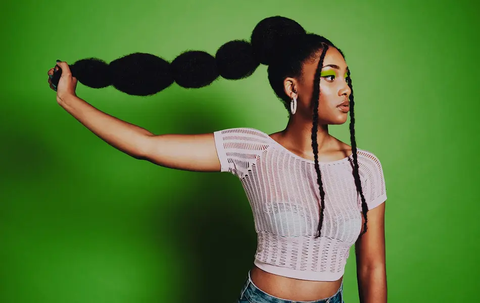 afro amerikansk dame som poserer med lang buble flette hår