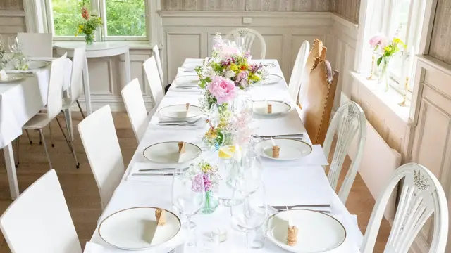 Hvitdekket bord dekorert med markblomster i små vaser