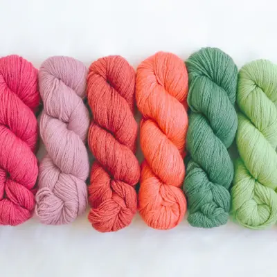 Fargede garnnøster som er flettet enkeltvis