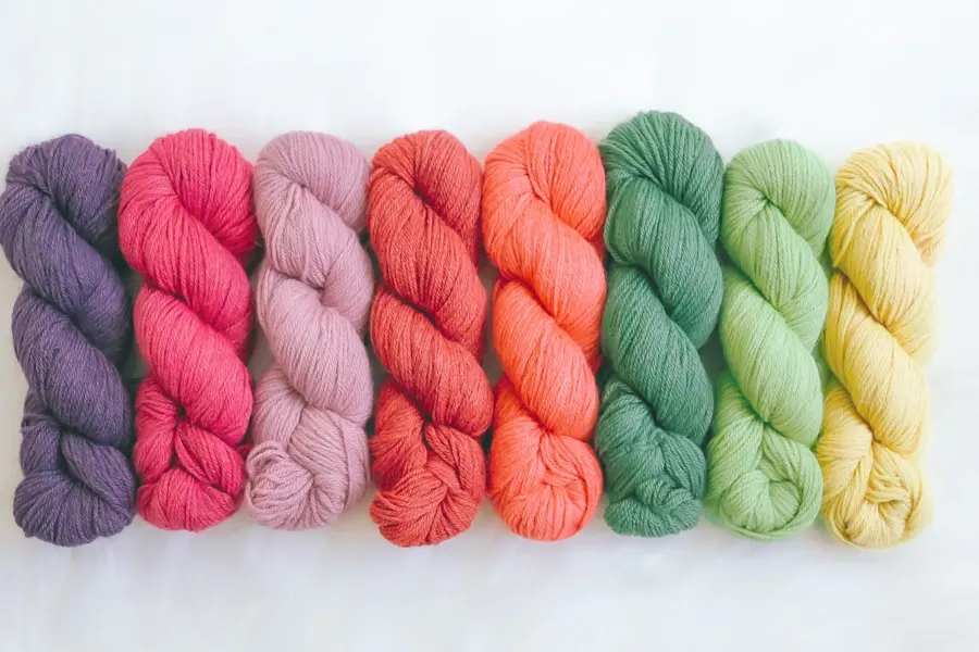 Fargede garnnøster som er flettet enkeltvis