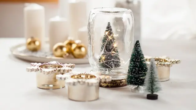 Glass med juletre, stearinlys, julekuler og diverse julepynt