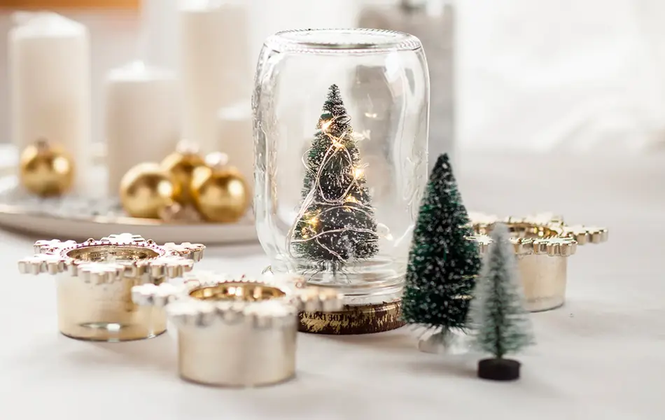 Glass med juletre, stearinlys, julekuler og diverse julepynt