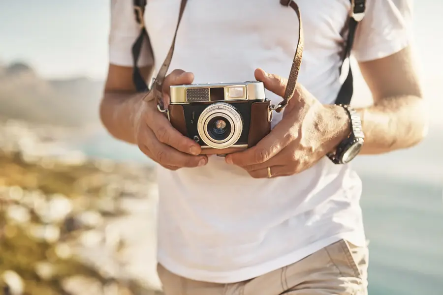 Cropped shot of an unrecognizable man hiking with his camera in the mountains