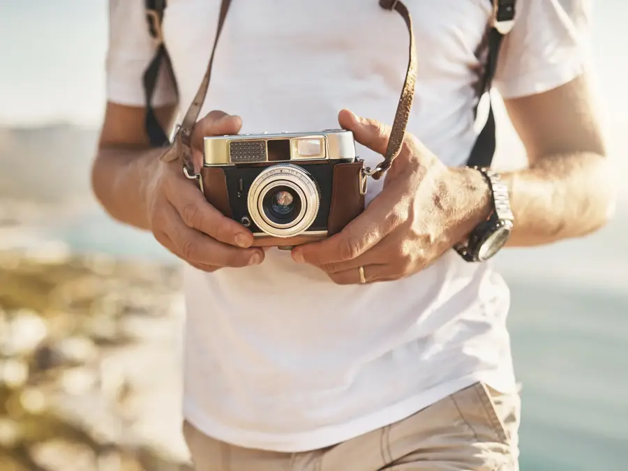 Cropped shot of an unrecognizable man hiking with his camera in the mountains