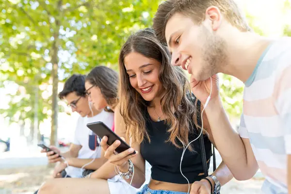 Flere ungdommer som hører på musikk gjennom øretelefoner