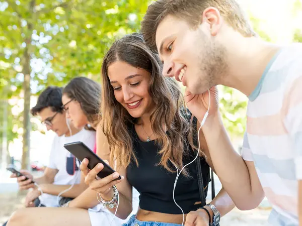 Flere ungdommer som hører på musikk gjennom øretelefoner