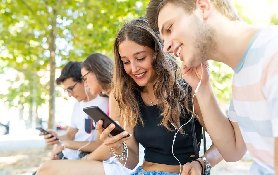 Flere ungdommer som hører på musikk gjennom øretelefoner