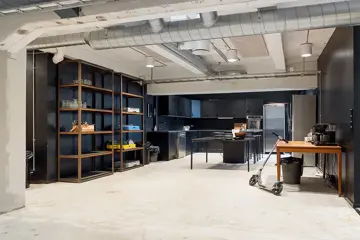 Interiør fra kontoret til The Oslo Company, kjøkkensone hvor rustikke detaljer som betong og ventilasjon er synlig