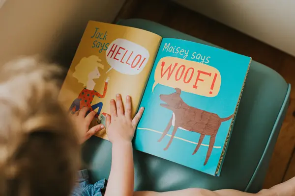 Little girl reading a simple picture book.