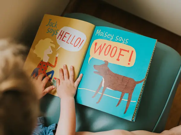 Little girl reading a simple picture book.