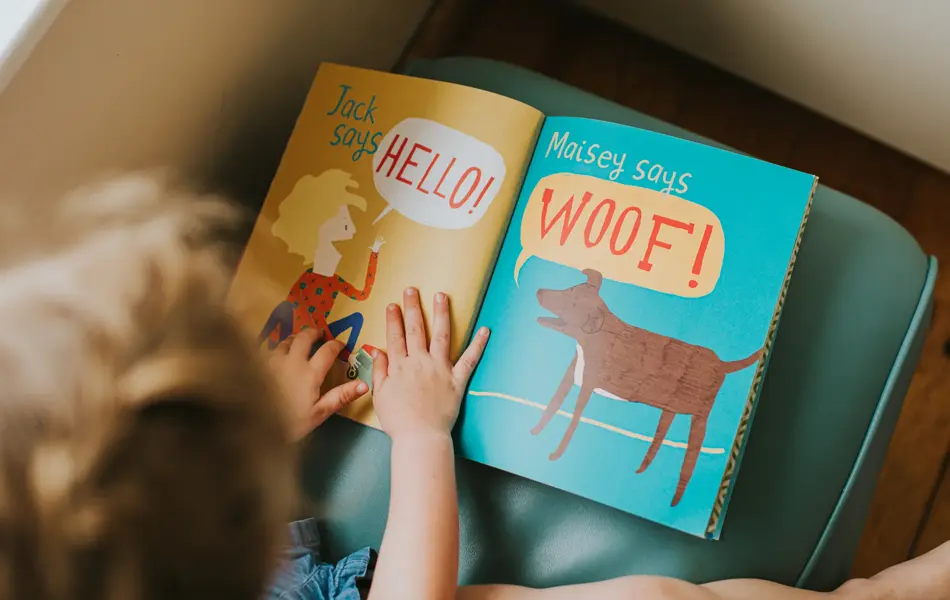 Little girl reading a simple picture book.