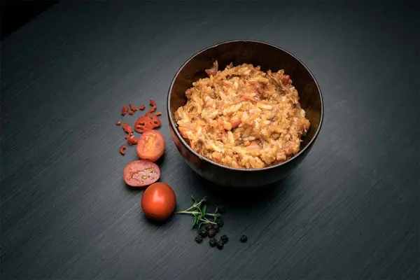 Pulled pork i en skål med tomater vedsiden av skålen