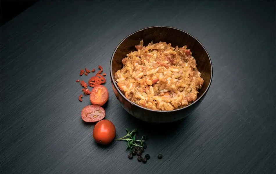 Pulled pork i en skål med tomater vedsiden av skålen