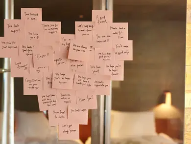 Lyserosa post-it-lapper plassert i en hjerteform på et speil