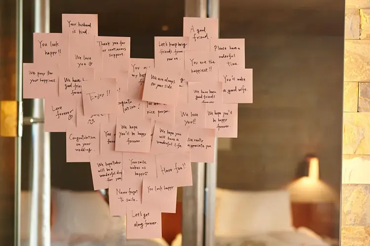 Lyserosa post-it-lapper plassert i en hjerteform på et speil