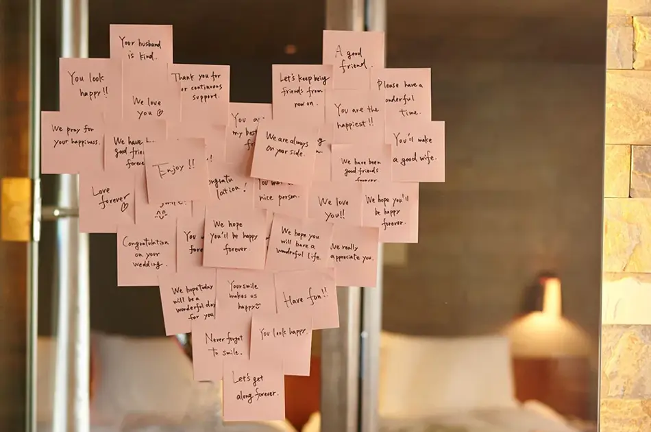 Lyserosa post-it-lapper plassert i en hjerteform på et speil