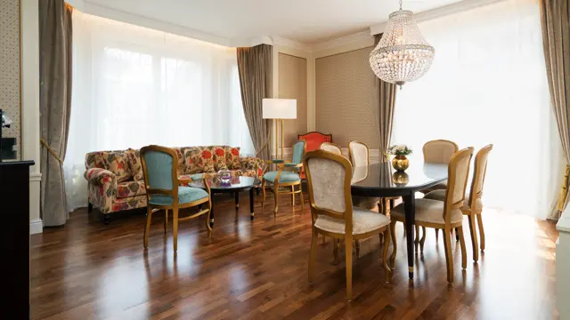 Sittegruppe med sofa og spisebord med stoler, lyskrone på suite på Hotel Bristol i Oslo sentrum