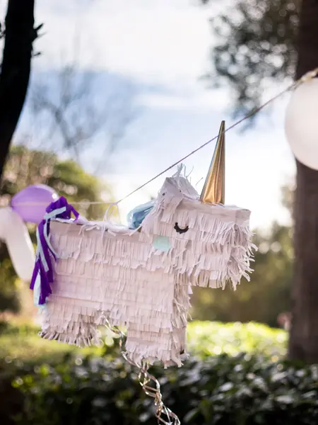 Pinjata formet som en enhjørning henger mellom to trær