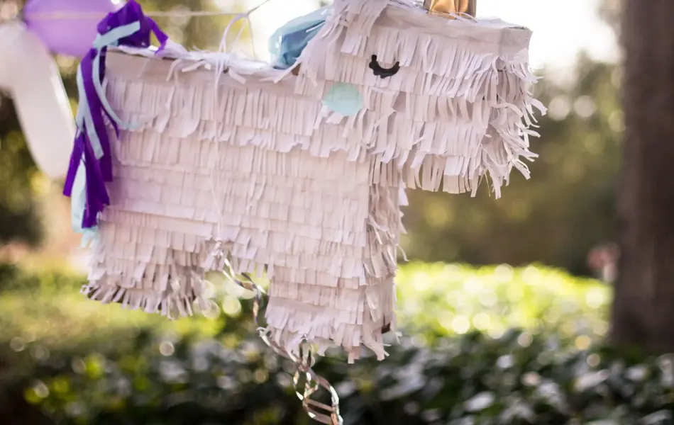 Pinjata formet som en enhjørning henger mellom to trær