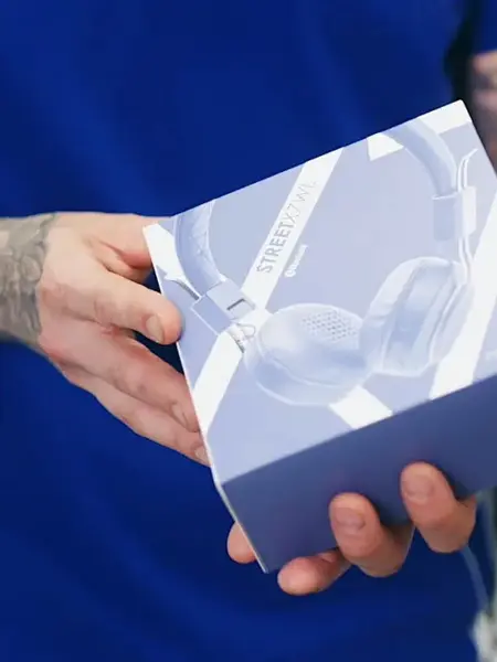 mann holder en eske med headset i