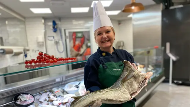 Dame som holder en skrei