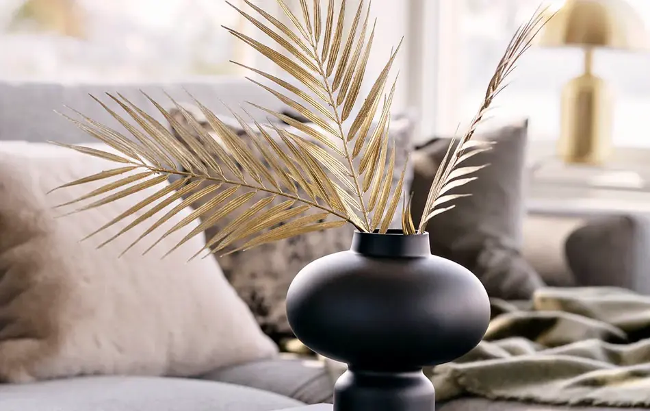 Sort firkantet bord med sort vase og beige tørkede blader