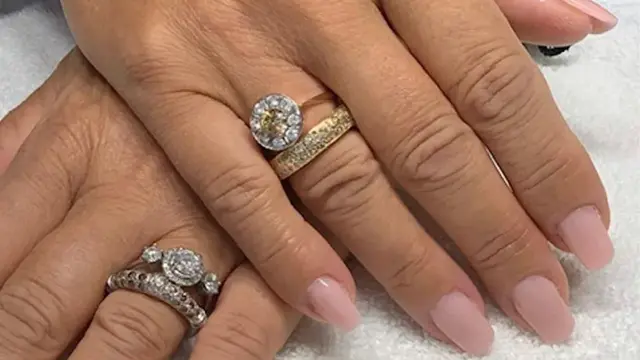 nærbilde av hender med nye negler, rosa neglelakk