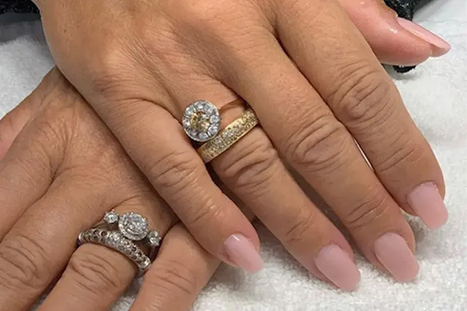 nærbilde av hender med nye negler, rosa neglelakk