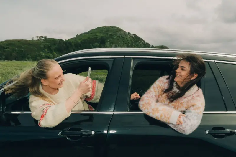 2 som henger ut av vinduy på bil