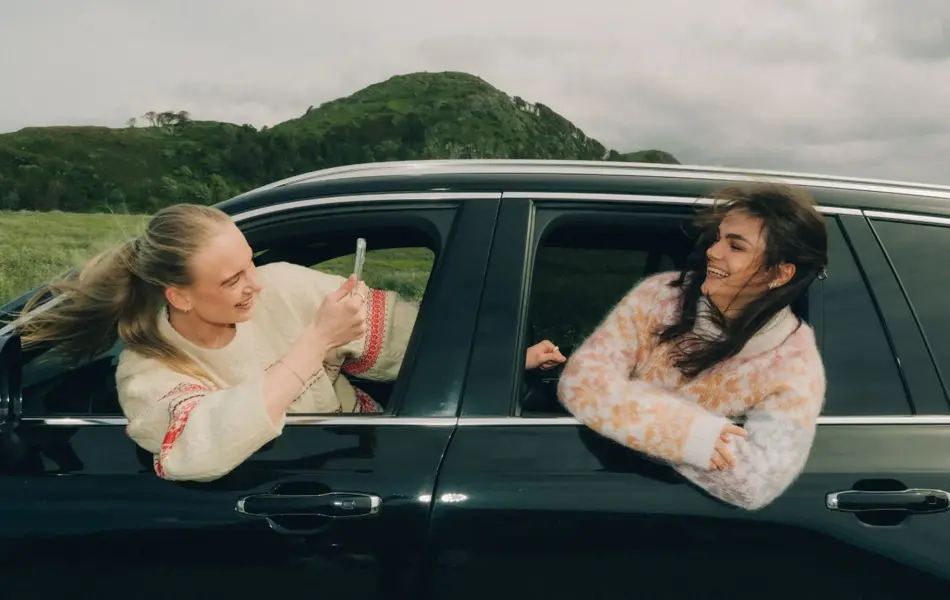 2 som henger ut av vinduy på bil