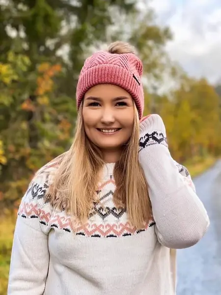 Ung kvinne med hvit strikkegenser og rosa strikkelue