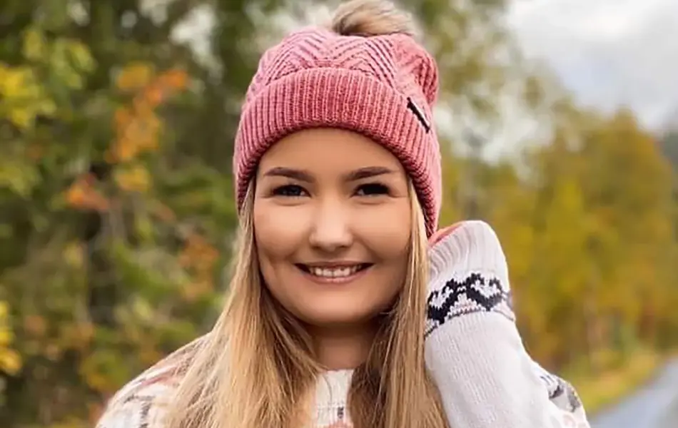 Ung kvinne med hvit strikkegenser og rosa strikkelue